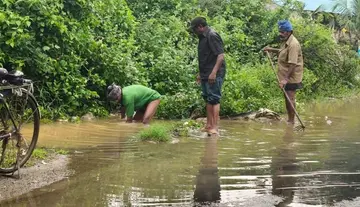 The hard work of sanitation workers in clearing floodwaters.